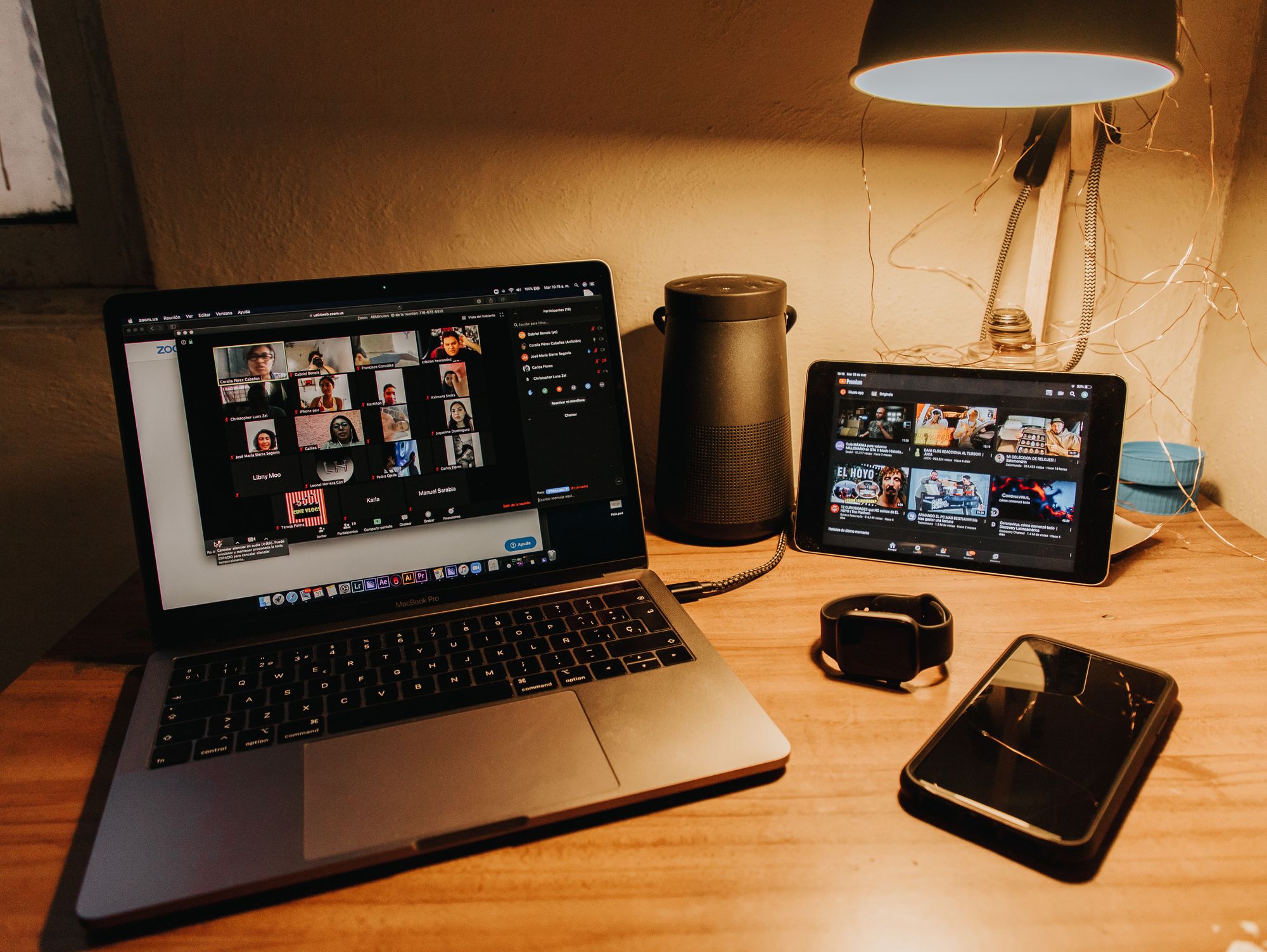 a laptop and a tablet showing many people on a zoom call.