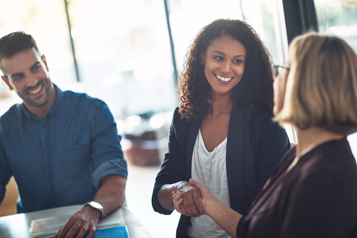 female employees shaking hands. hiring female talent.