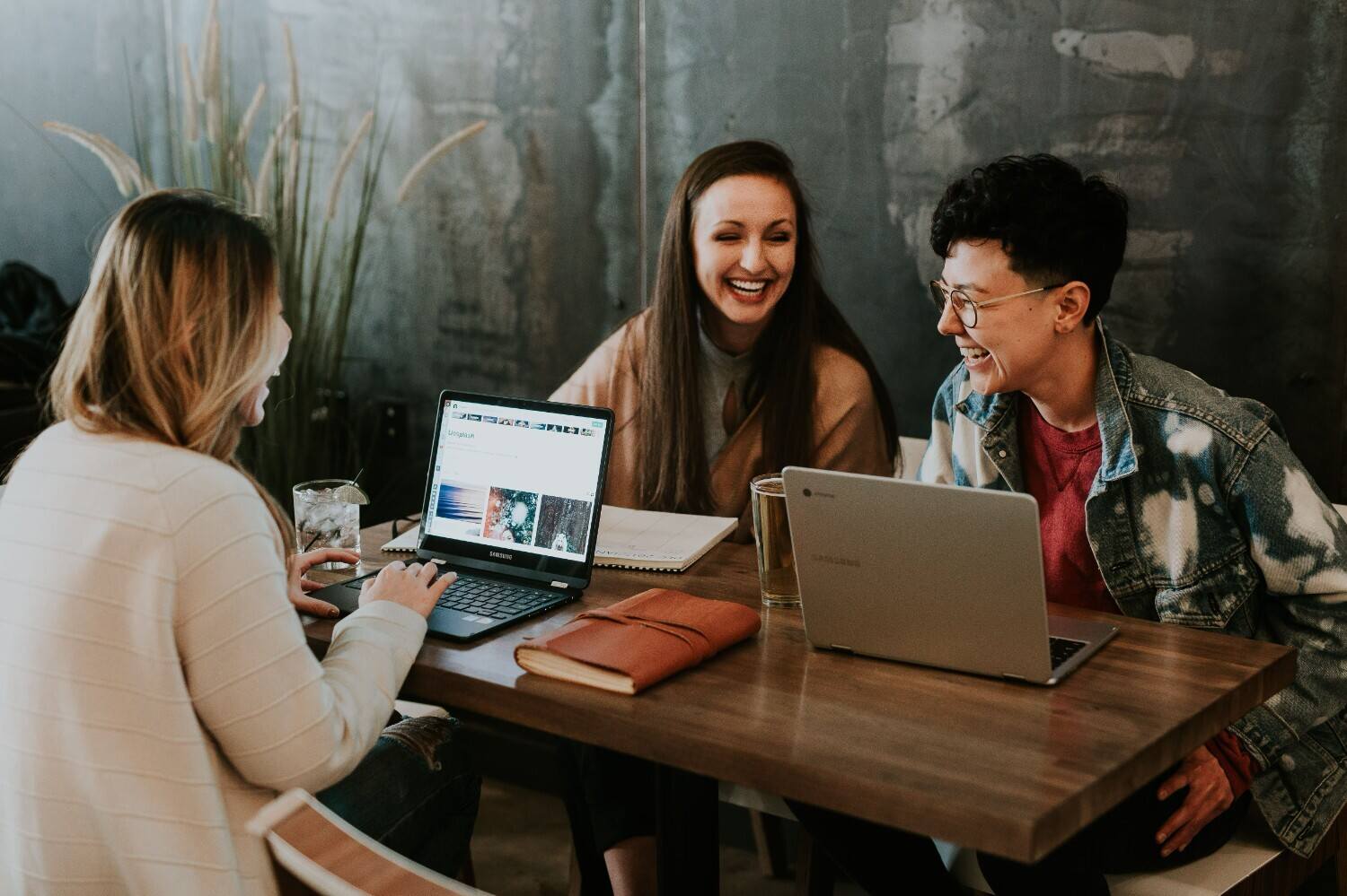 gender diverse employees. female employees in the workplace. working on their laptops.